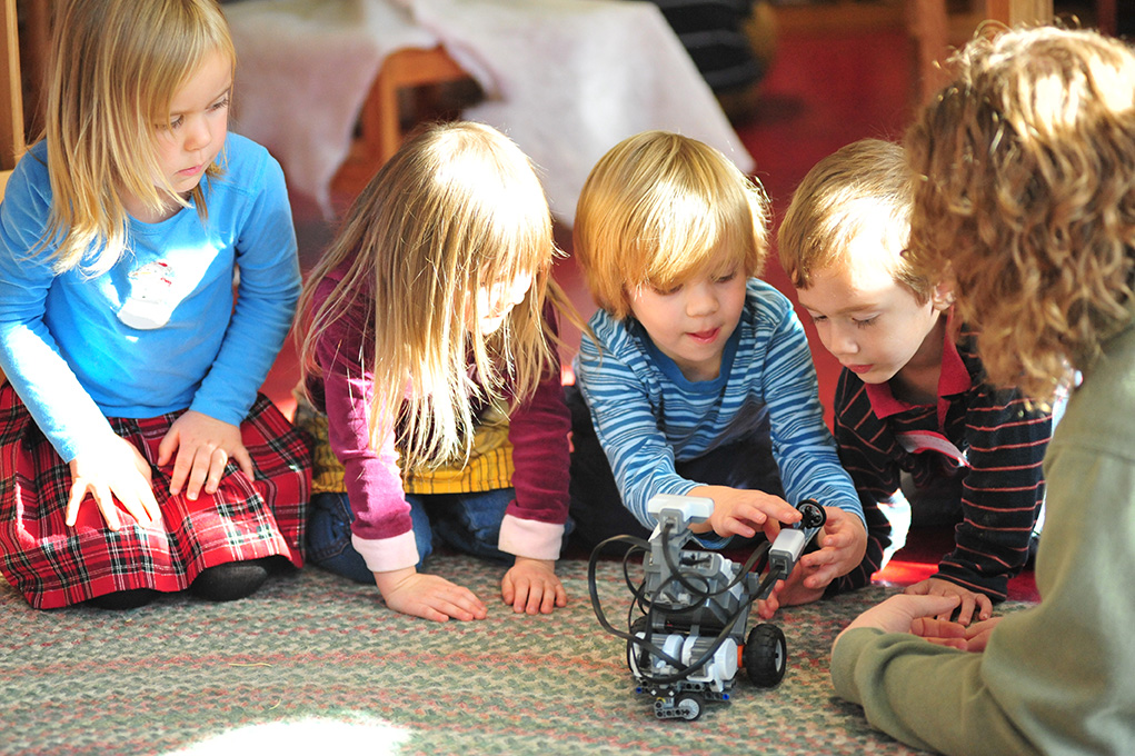 Artificial intelligence solutions super easy Our vision of humans, data and decisions.Children playing with a robot developed with artificial intelligence solutions.